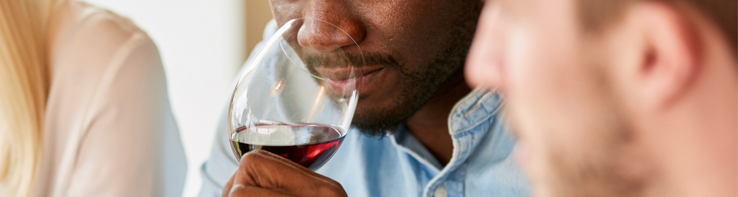 Cape Winelands has been producing fine wines and wineries in South Africa have won many awards for their world-class wine farms in Cape Town. Man is smelling wine and soaking in the wine tasting 