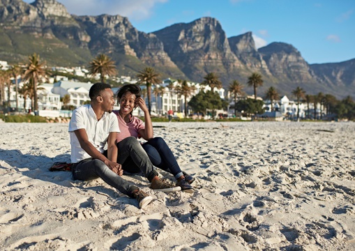  People enjoying the beach in Camps bay with Twelve Apostles, Cape Town, South Africa
