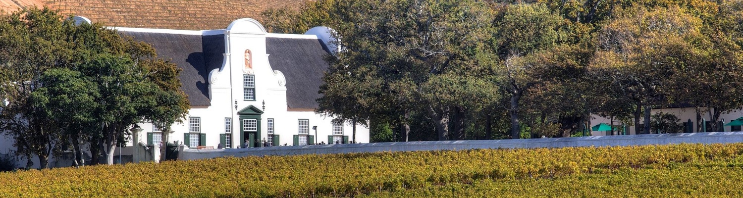 A picture of the Cape Dutch Architecture found in Stellenbosch wineries.  Tourists will see wineries in Stellenbosch on a private guided tour  with into tours Cape Town 